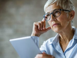 Concerned older woman with tablet computer