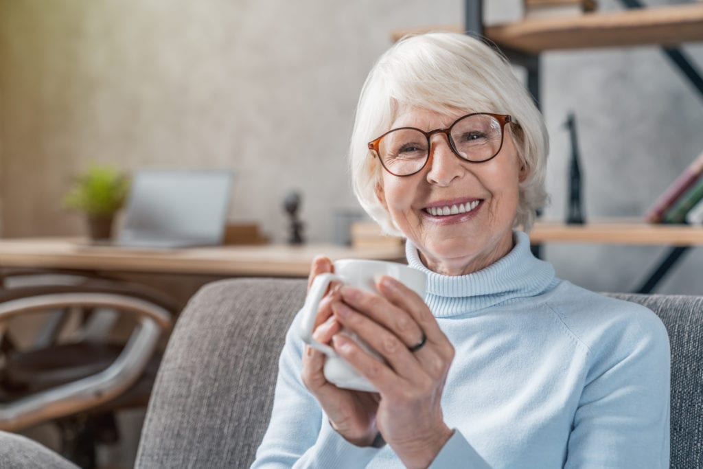 Senior woman smiling and enjoying a hot drink