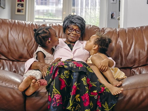 Senior woman with her grandkids on a couch