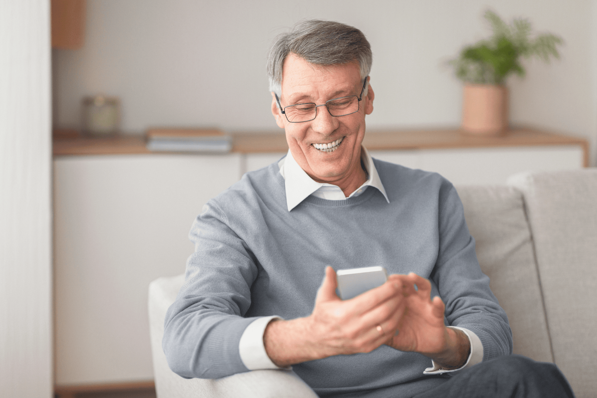 A older man smiling at phone