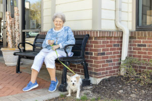 senior woman walking her dog around The Terrace Retirement Community